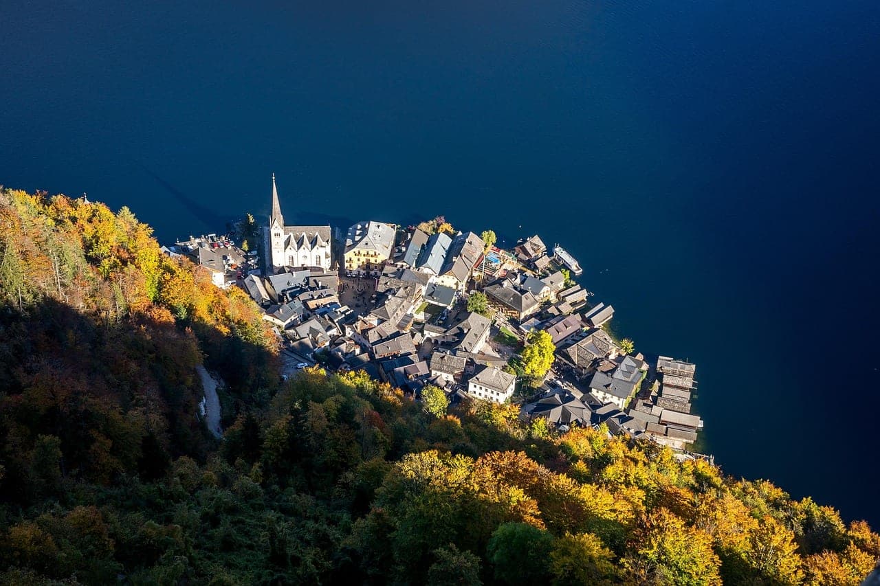 Austrian alpine village reflected on a glacial lake framed by Salzkammergut peaks