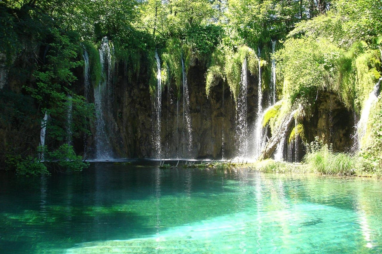 Turquoise lakes and wooden boardwalks winding through Plitvice's terraced waterfalls in Croatia