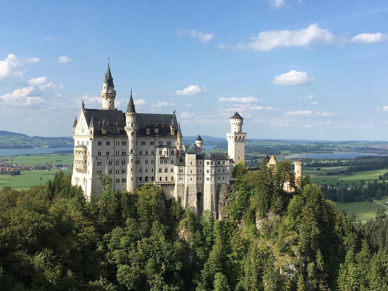 Neuschwanstein Castle perched above a Bavarian Alpine forest in late autumn