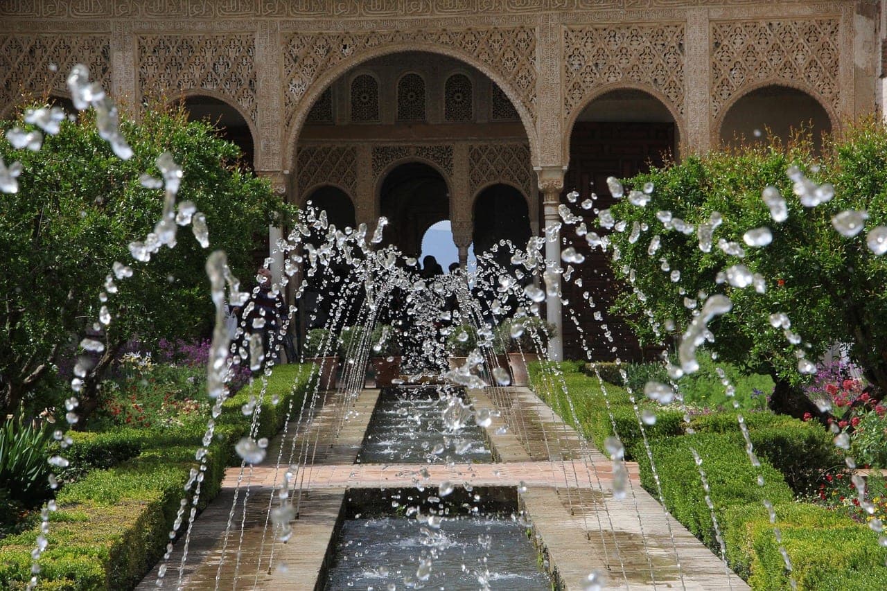 Moorish arches and a reflecting pool in the Alhambra courtyards above Granada, Spain
