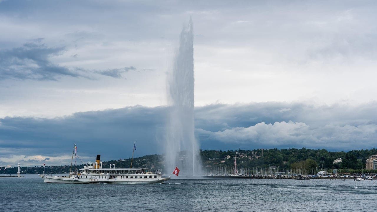 Jet d'Eau fountain rising from Lake Geneva with the Alps in the distance