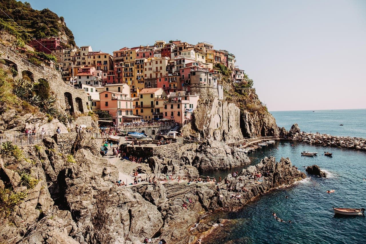 Pastel-colored seaside village on the Italian Riviera coast with beach and turquoise water