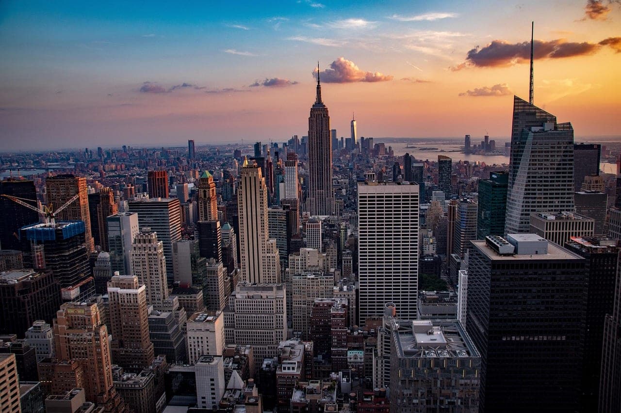 Manhattan skyline at sunset with the Empire State Building and One World Trade above the city