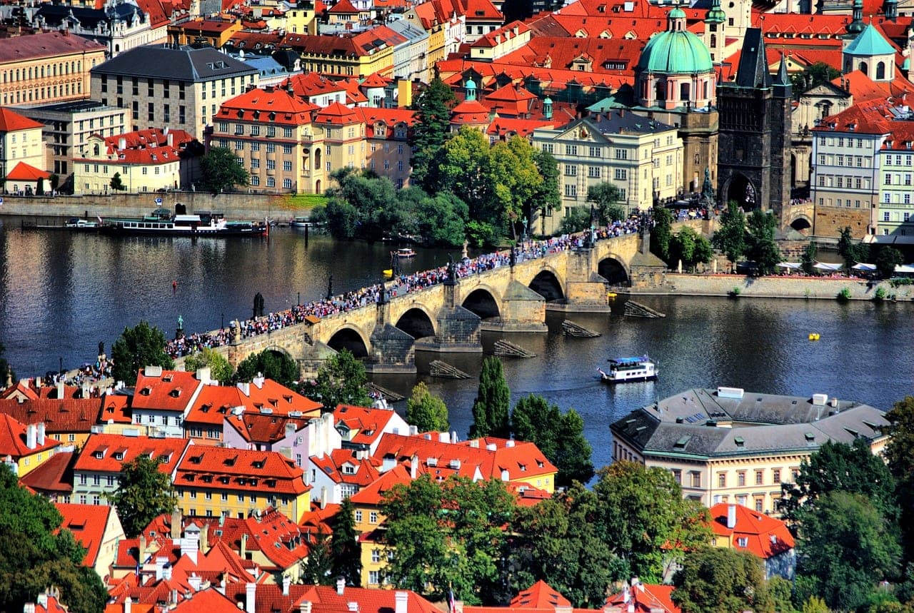 Charles Bridge over the Vltava with Prague Castle and Gothic towers at sunrise