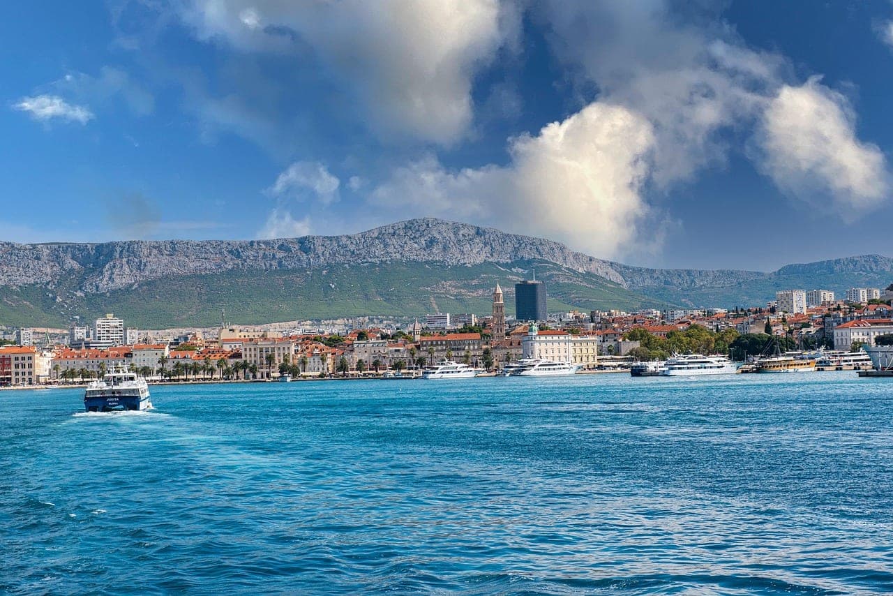 Split's palm-lined Riva waterfront and Diocletian's Palace at the harbor of Split, Croatia
