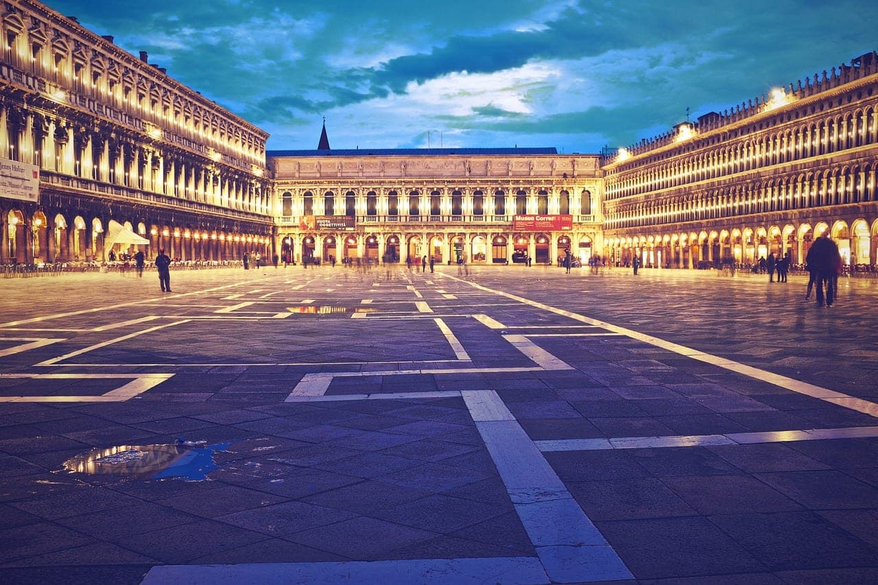 Venice Grand Canal at sunset with gondolas and pastel palazzo facades along the water
